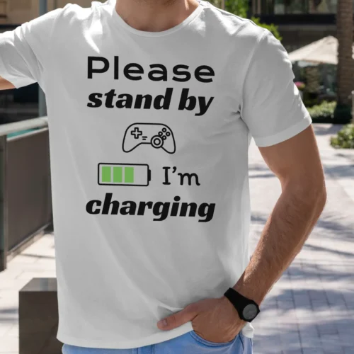 Funny T-Shirt for Gamers featuring a picture of a gamepad and saying "Please stand by, I'm charging". White color