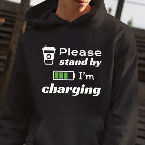 Funny hoodie for Coffee Lovers featuring a picture of a coffee cup and a battery saying "Please, stand by. I'm charging". Black color