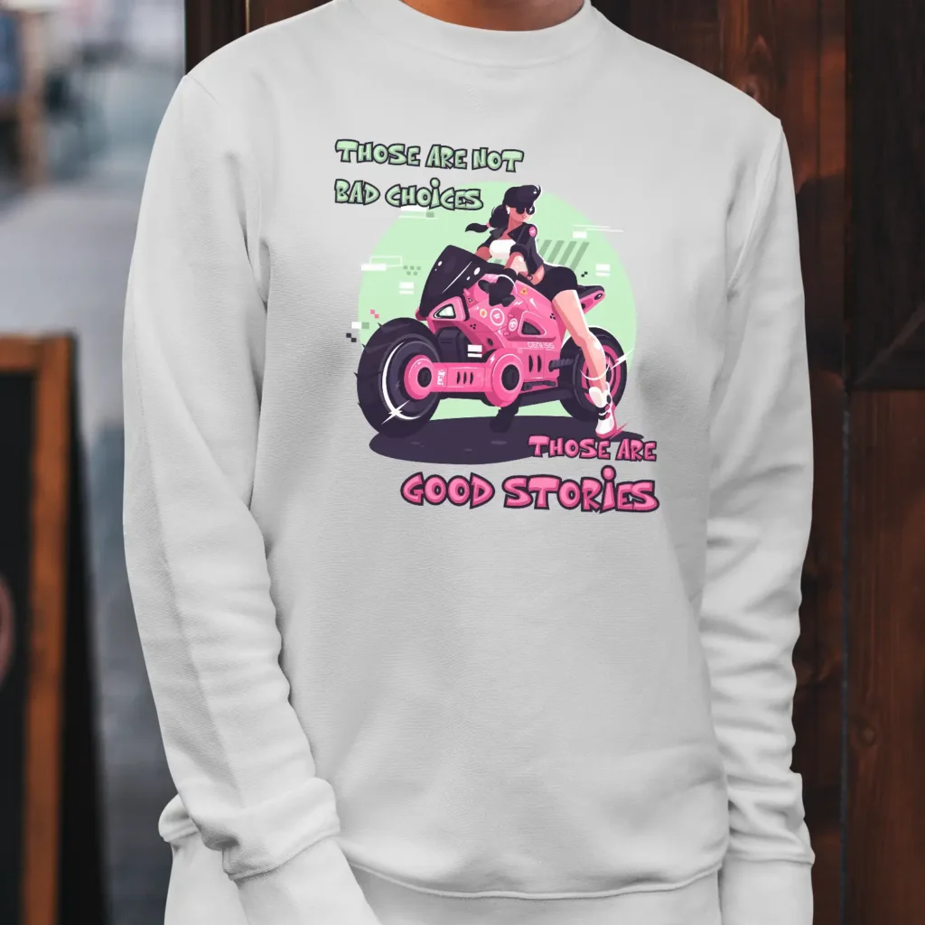 A white Funny Sweatshirt featuring a pink and green picture of a girl on a motorcycle saying "Those are not bad choices, those are good stories".