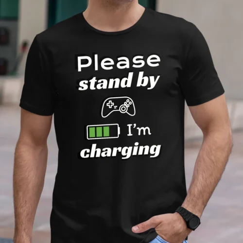 Funny T-Shirt for Gamers featuring a picture of a gamepad and saying "Please stand by, I'm charging". Black color