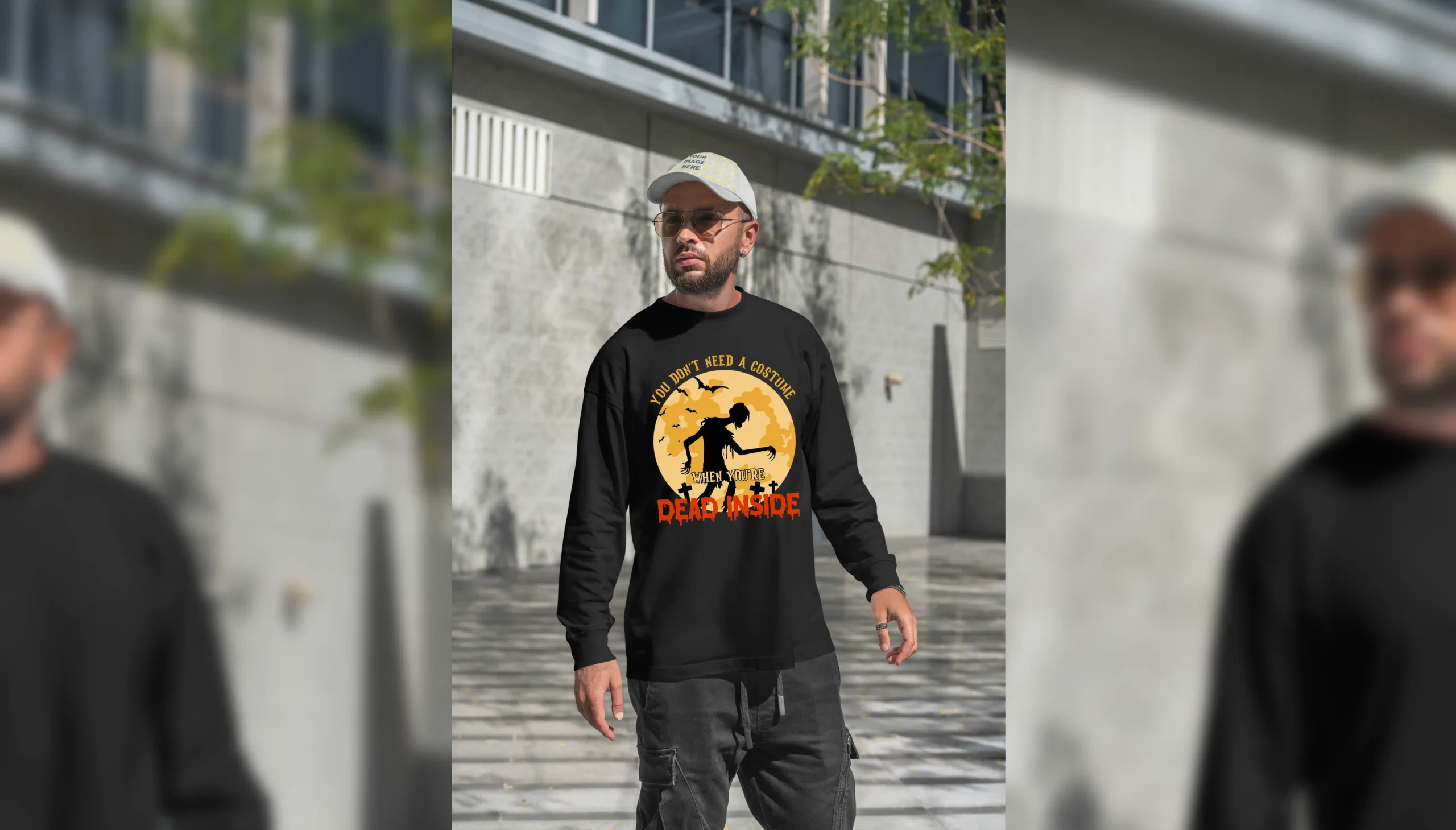 A young man outside wearing a funny Halloween Sweatshirt with a zombie print saying "You don't need a costume when you're dead inside". Black color