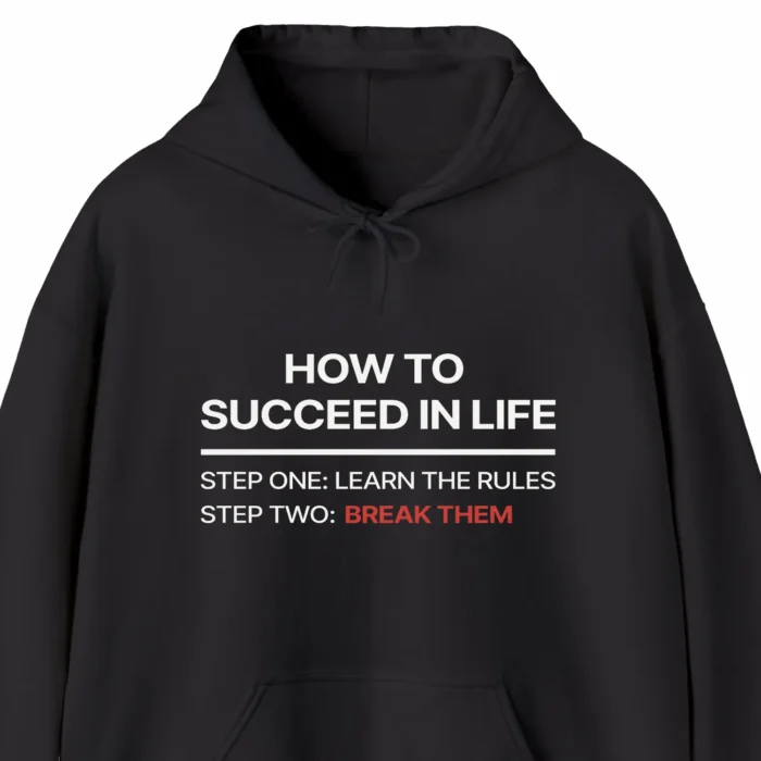 A funny hoodie saying "How to succeed in life: step one, learn the rules, step two, break them", black color