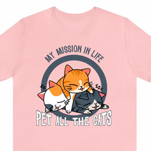 A funny t-shirt with a picture of cute cats, saying "My mission in life is to pet all the cats", pink